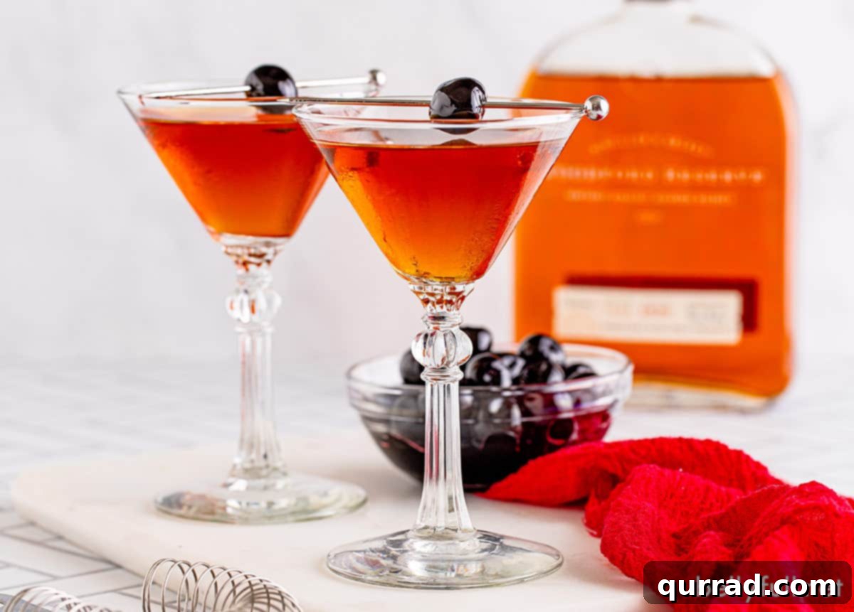 A Taste of Old New York 3 Two exquisite Manhattan cocktails presented in classic coupe glasses, ready to be enjoyed in a sophisticated setting.