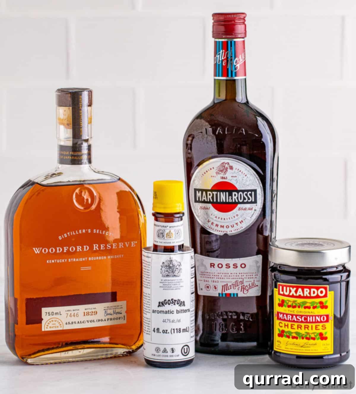 A Taste of Old New York 4 Essential ingredients for a Classic Manhattan cocktail: a bottle of rye whiskey, sweet vermouth, Angostura bitters, and vibrant Luxardo cherries.