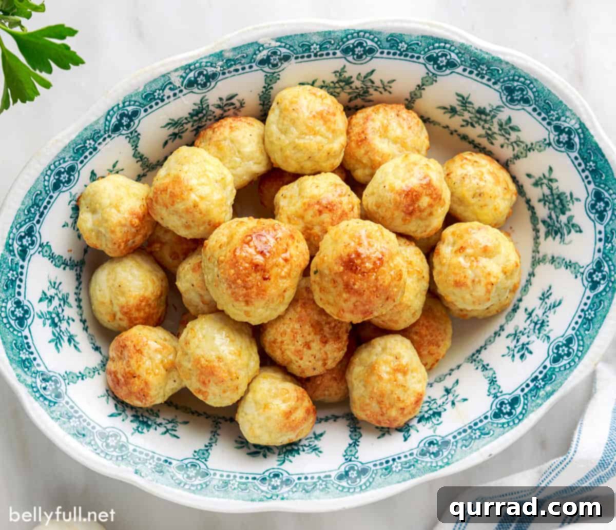 Savory Chicken Meatballs 6 Overhead view of several baked chicken meatballs artfully arranged in a blue and white patterned serving dish, ready to be enjoyed.