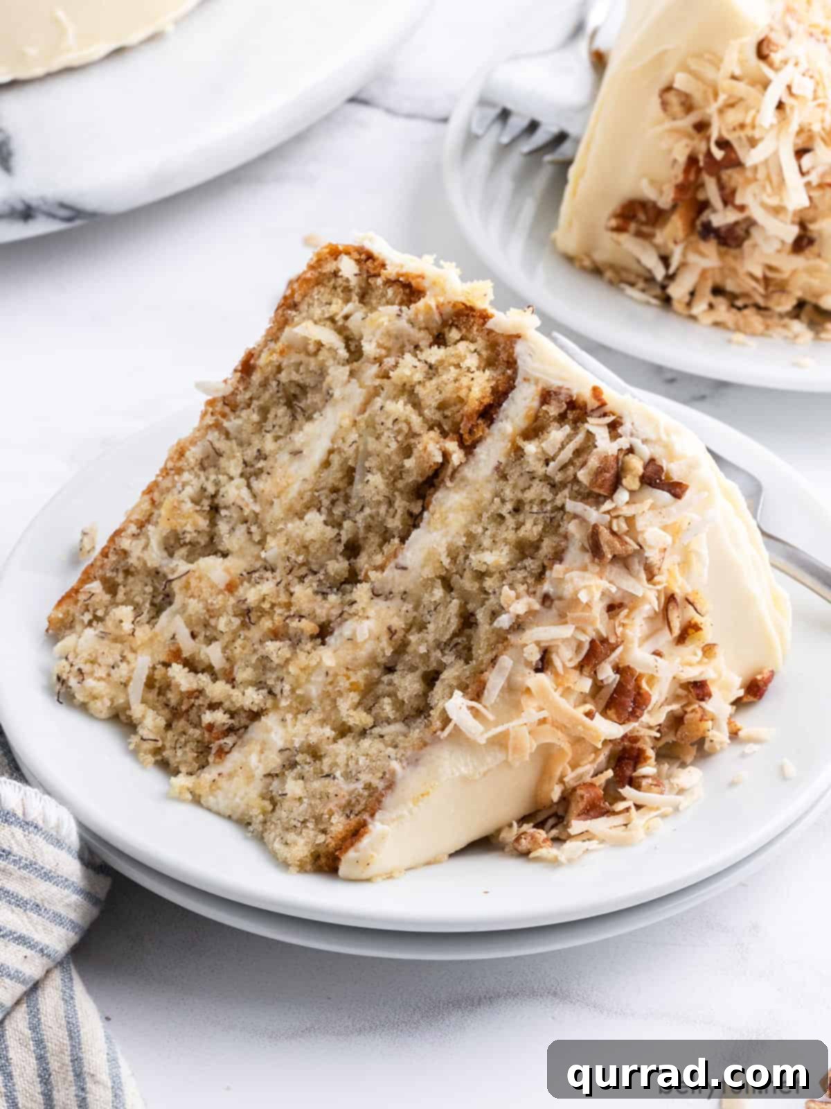 Golden Nectar Dream 6 A pristine slice of Hummingbird Cake sits elegantly on a white plate, ready to be enjoyed, showing off its layers and frosting.