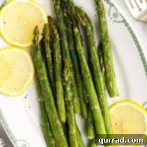 Crispy Air Fryer Asparagus 6 Overhead view of air fryer asparagus on a plate with lemon slices