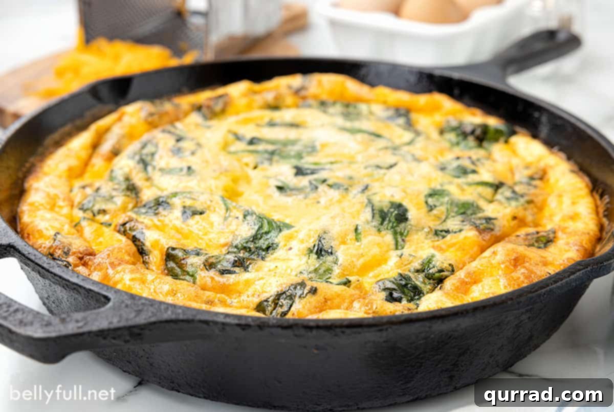 Hearty Ham and Spinach Frittata Skillet 5 Spinach frittata in a cast iron skillet, sliced into wedges.