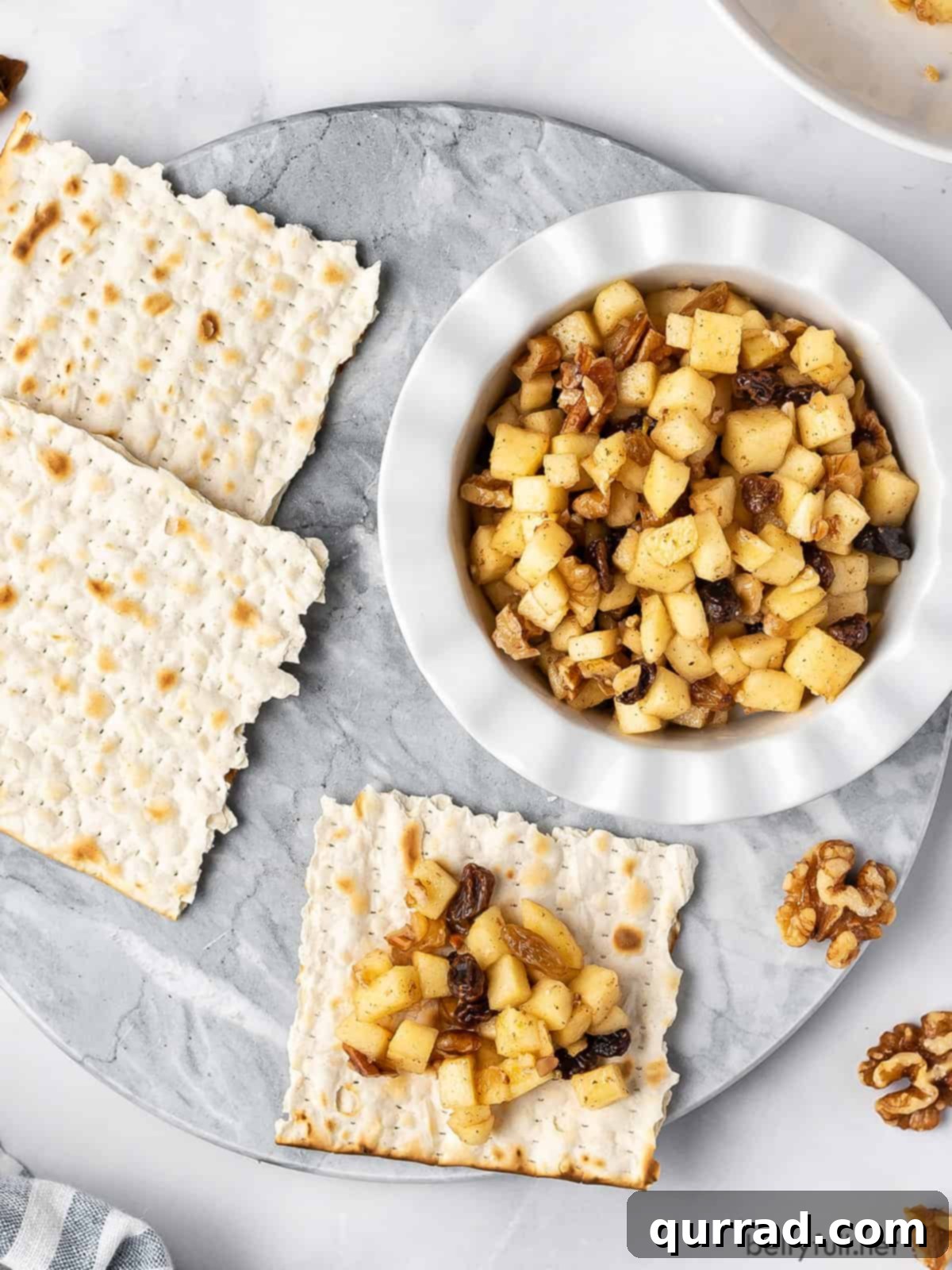 Sweet Paste of Passover 3 An inviting overhead shot of a bowl of Charoset, perfectly portioned alongside crispy matzo crackers, ready for a Passover Seder.