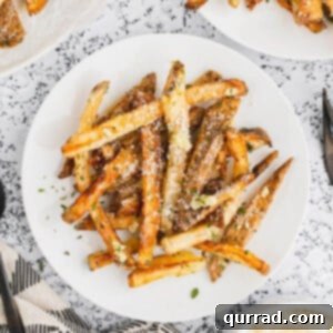 Overhead view of a white plate of garlic parmesan fries