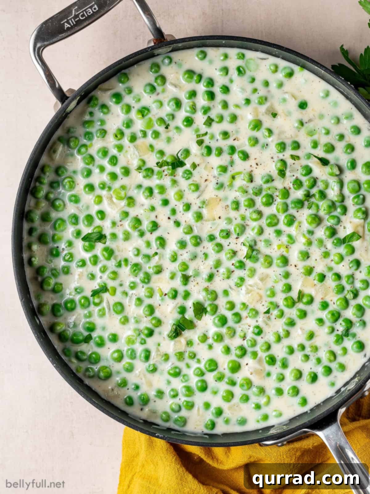 Creamy Braised Peas 3 Overhead view of creamy peas in a skillet