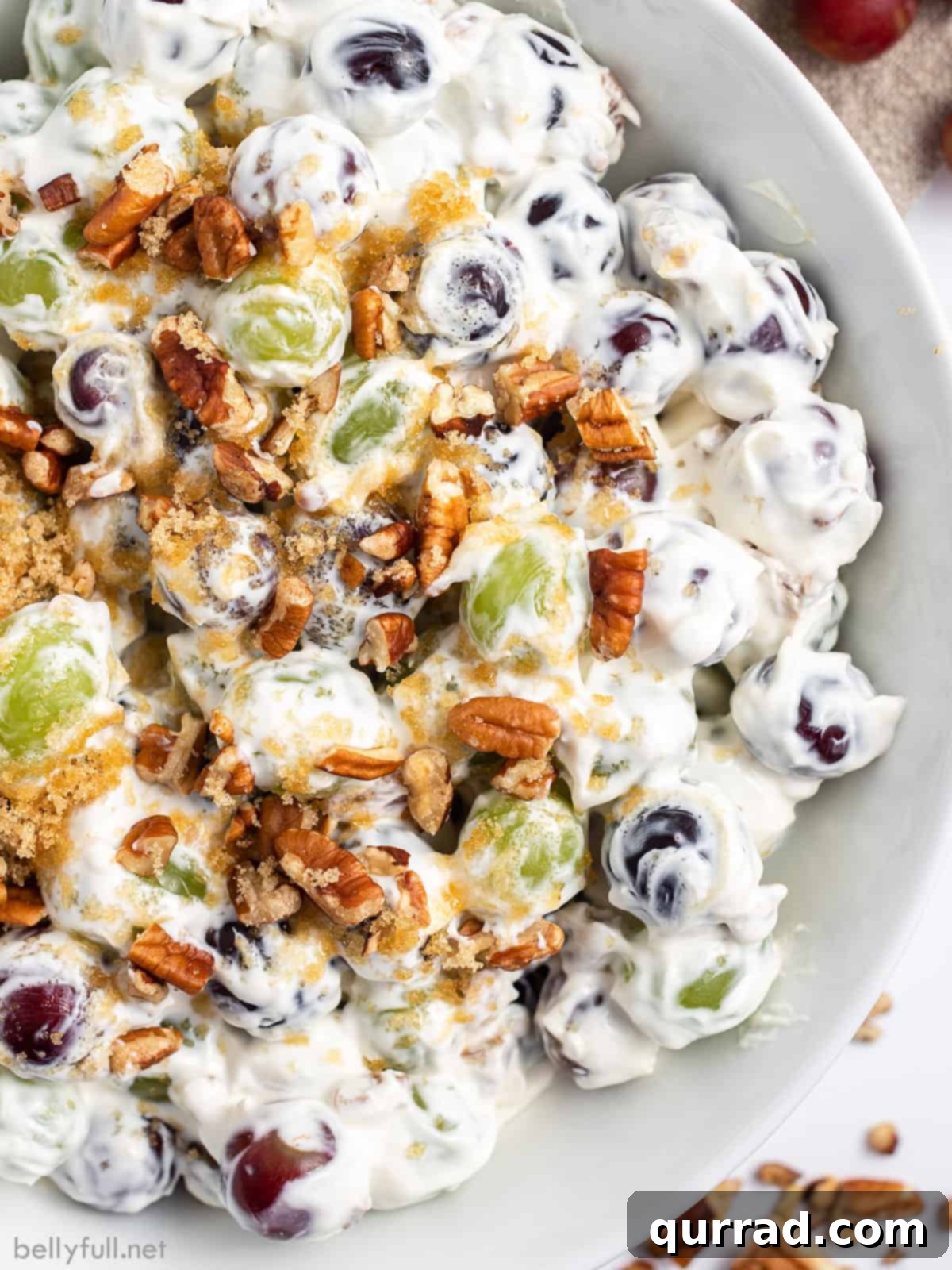 Close-up view of a bowl of creamy grape salad, ready to be served.
