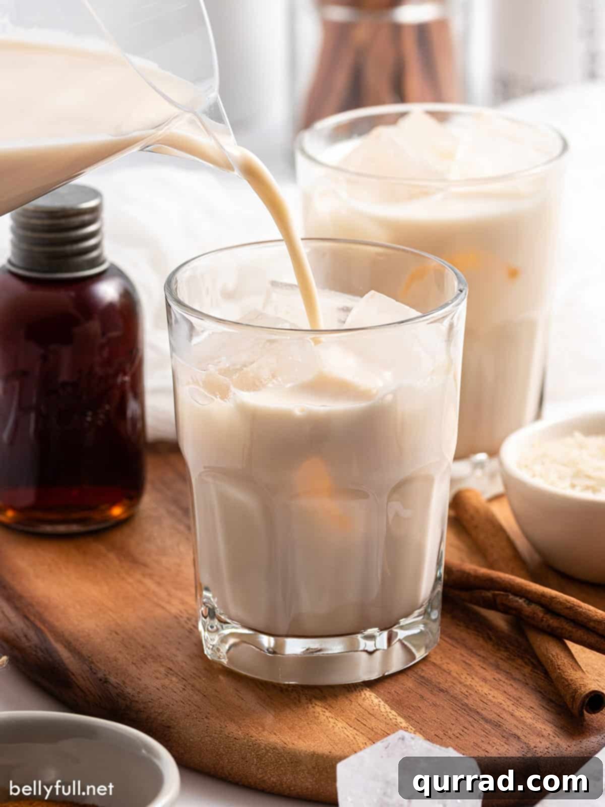 Creamy Cinnamon Mexican Horchata 7 Horchata being poured from pitcher into glass with ice.