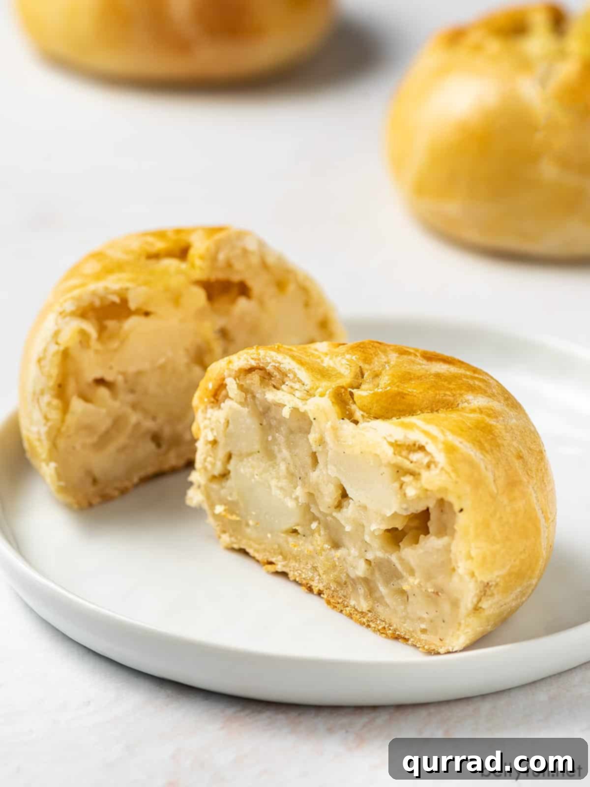 Flaky Potato Pastry 4 potato knish cut in half on white plate