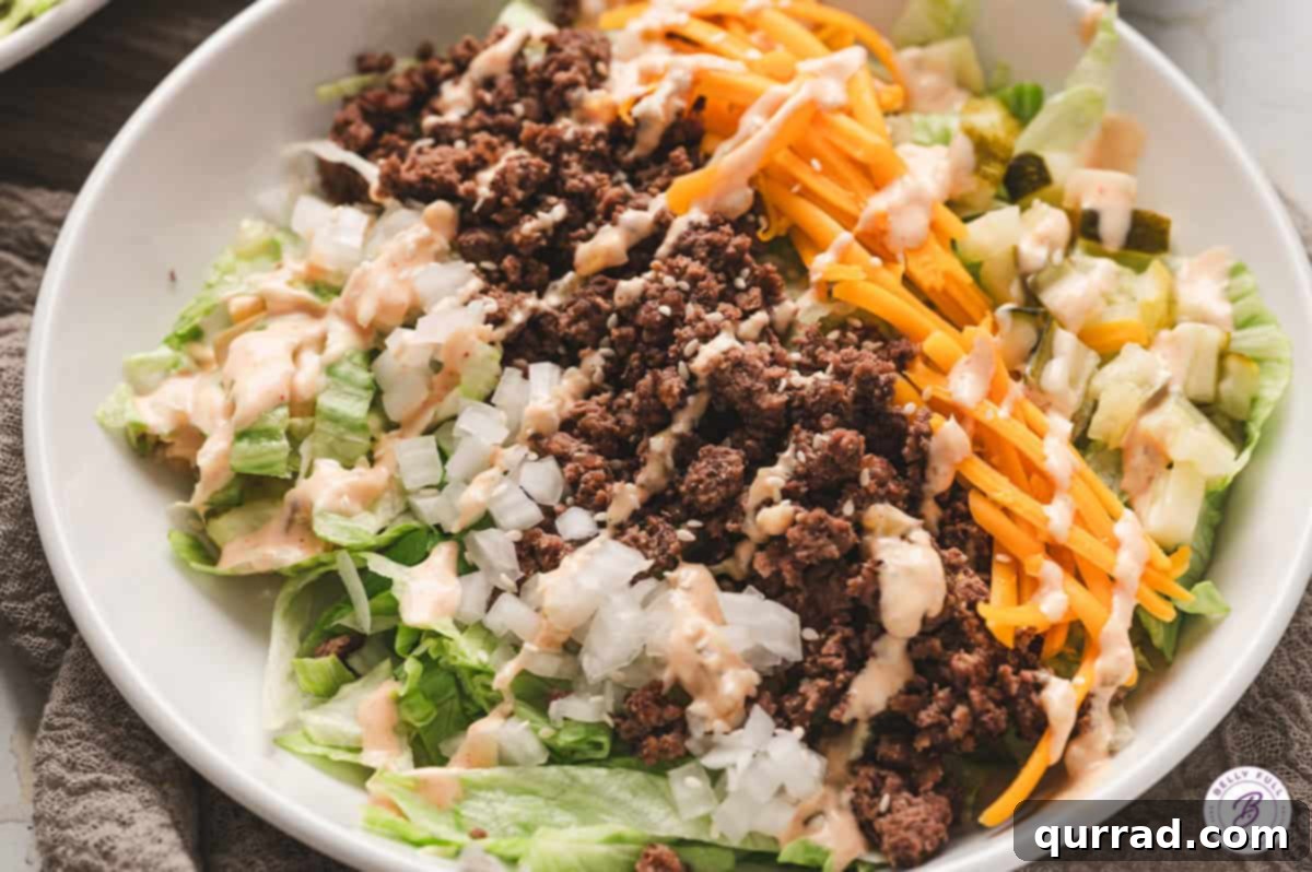 A close-up of the Big Mac Salad showing the generous drizzle of sauce and fresh ingredients, enticing viewers to try the recipe.