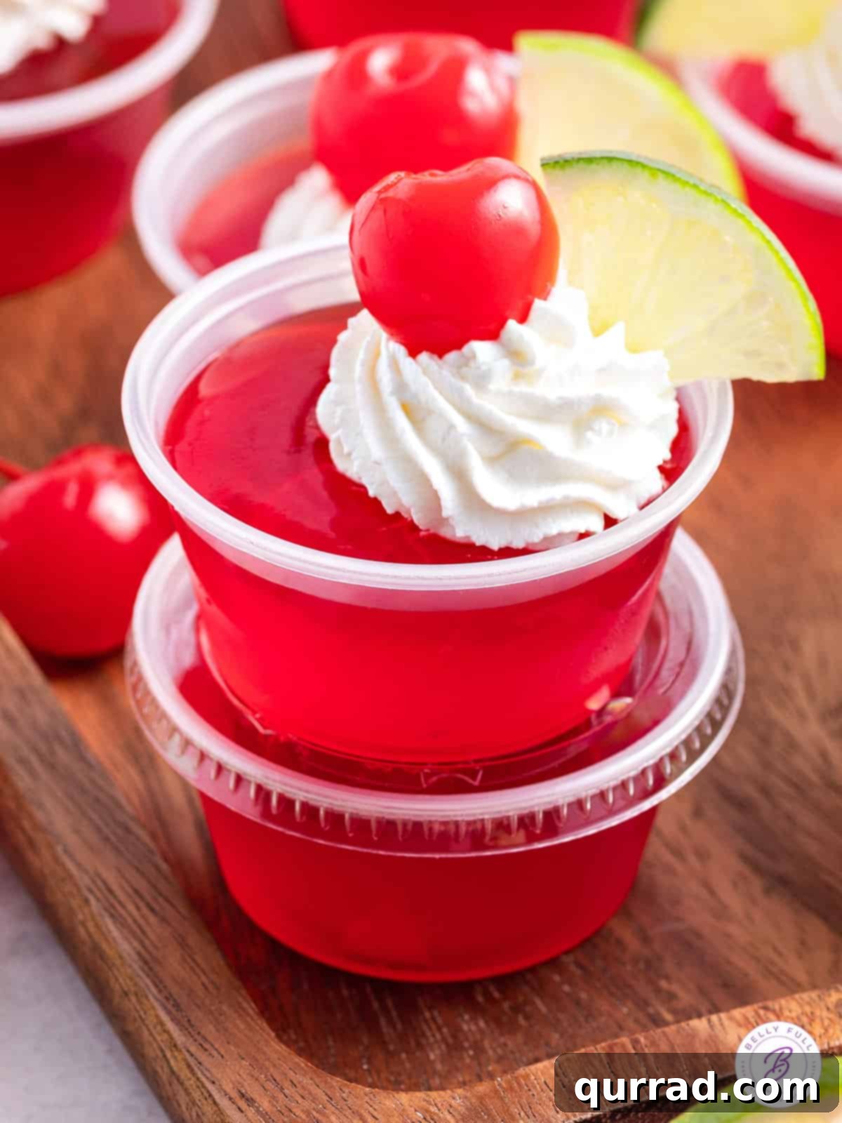 Tipsy Shirley Gel Bites 2 2 stacked cherry jello shots garnished with whipped cream, cherry, and lime