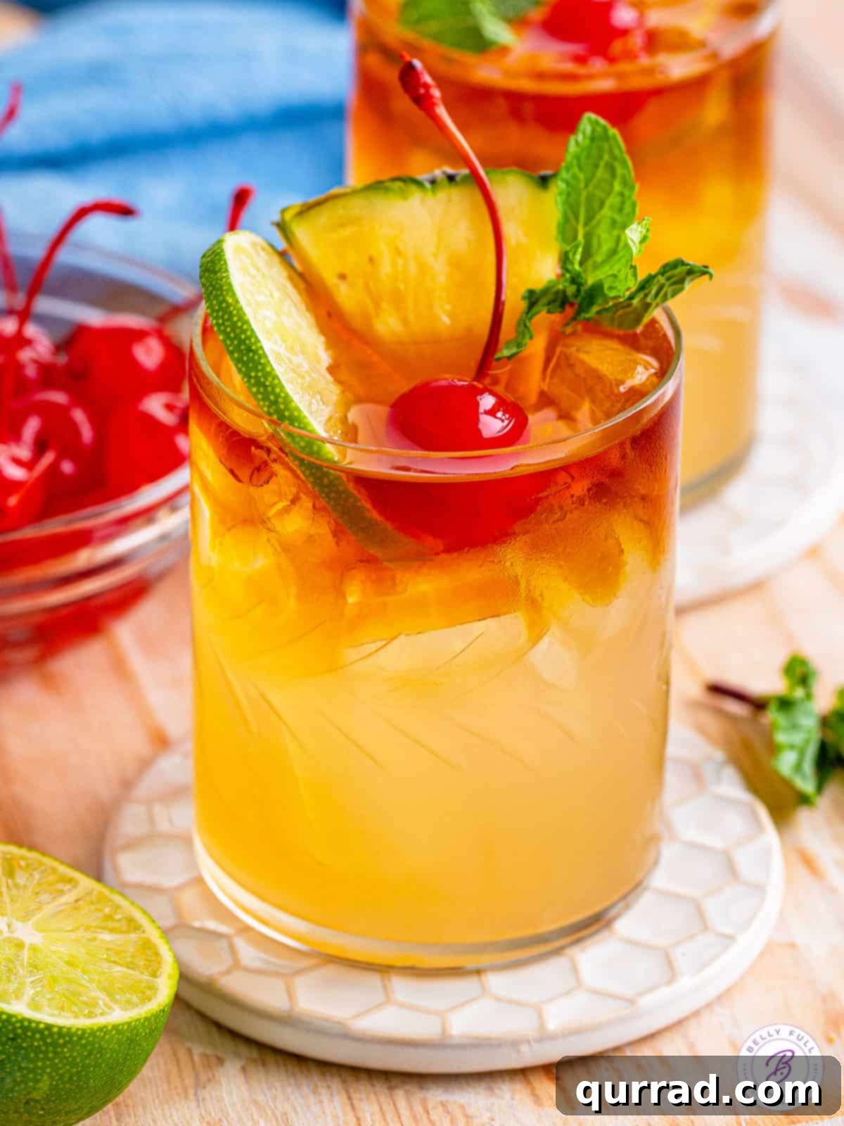 Tropical Bliss in a Glass 2 Overhead angled view of a Mai Tai cocktail garnished with lime, pineapple, and a cherry, showcasing its vibrant colors and elegant presentation.