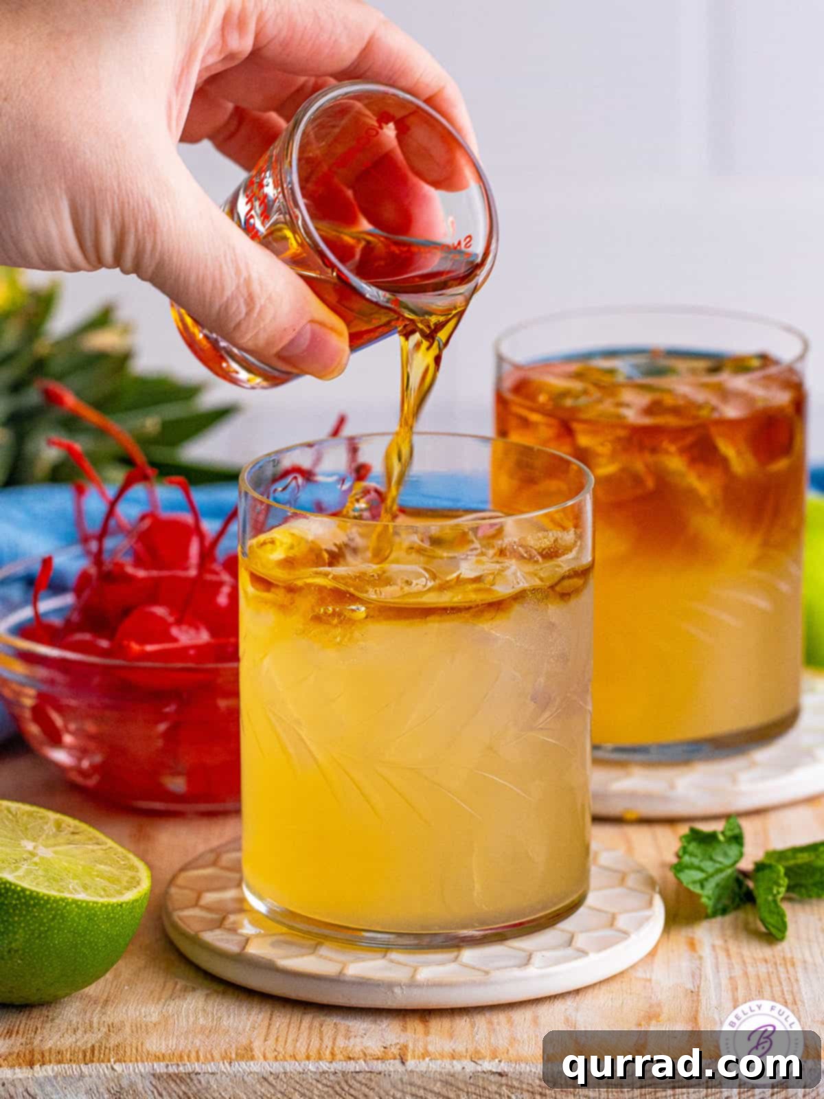 Tropical Bliss in a Glass 4 Dark rum being expertly poured over the top of a Mai Tai cocktail, creating a visually striking layered effect.