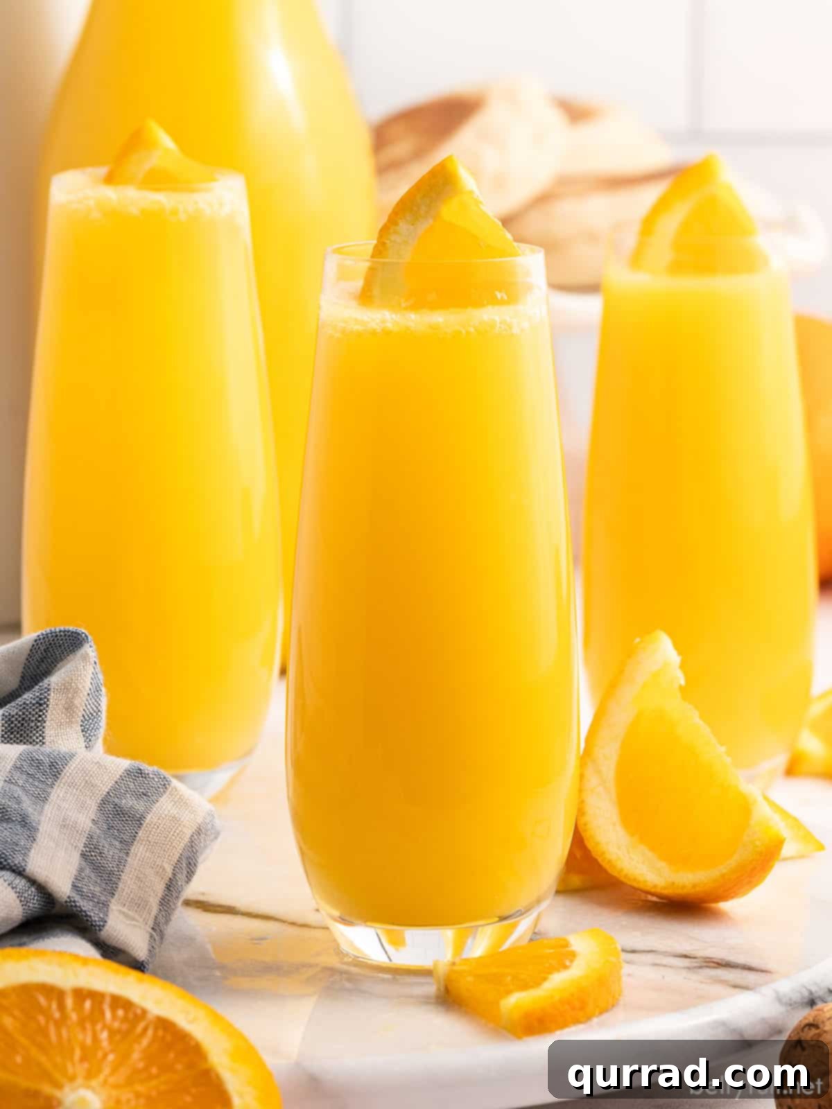 Tropical Sunrise Mimosa 4 3 glasses of Pineapple Sunrise Mimosas with orange and pineapple slice garnish