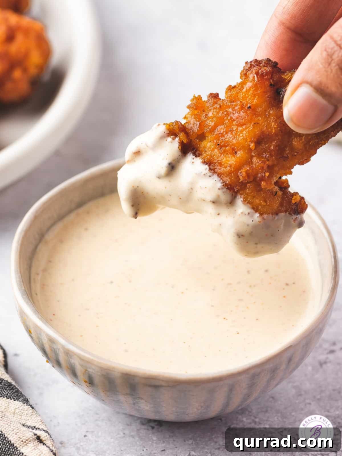 Alabama's Signature White Sauce 4 A piece of chicken dipped into Alabama white sauce