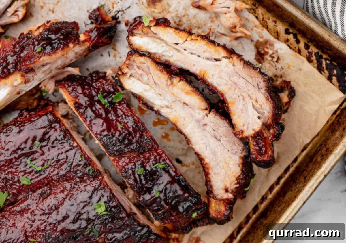 Overhead view of instant pot baby back ribs on a baking sheet, freshly sauced