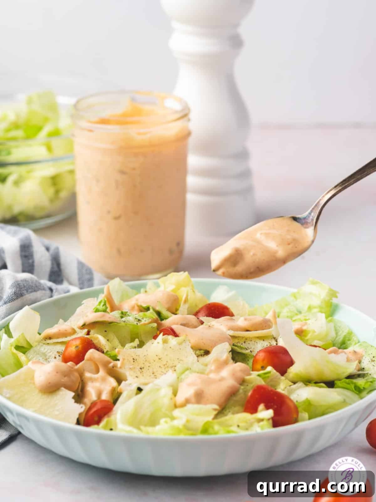 Homemade Thousand Island Dressing being spooned over a fresh salad, highlighting its perfect consistency and inviting appeal.