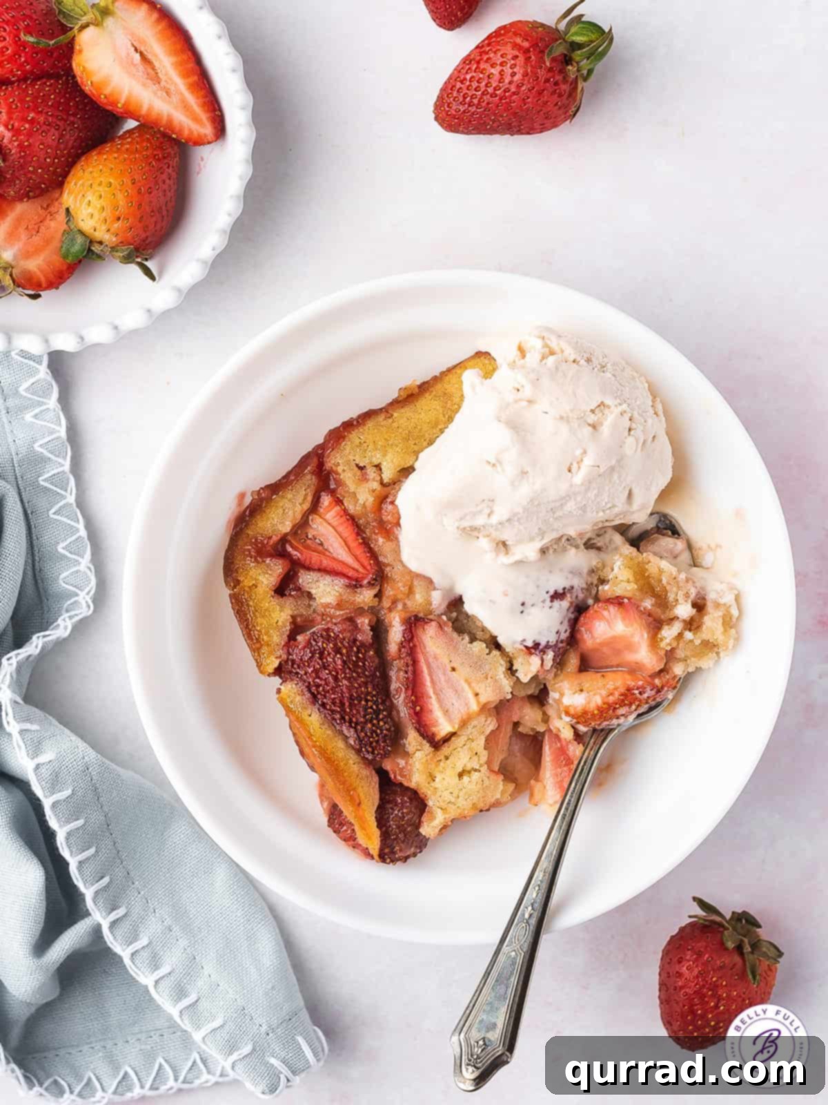 Sweet Summer Strawberry Cobbler 2 Overhead view of a serving of strawberry cobbler in a bowl with melting vanilla ice cream