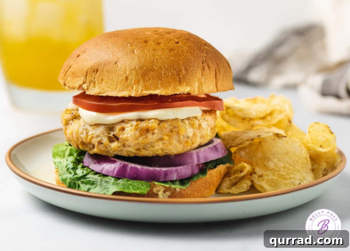 Beyond Basic Chicken Burgers 6 Homemade chicken burger on a bun served on a plate with potato chips as a side