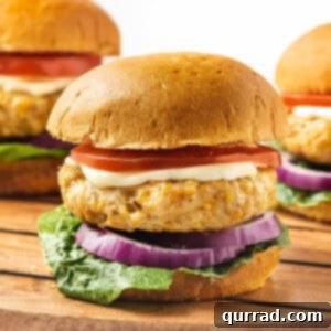 Beyond Basic Chicken Burgers 7 Front view of a ground chicken burger on a bun with tomato, onion, and lettuce