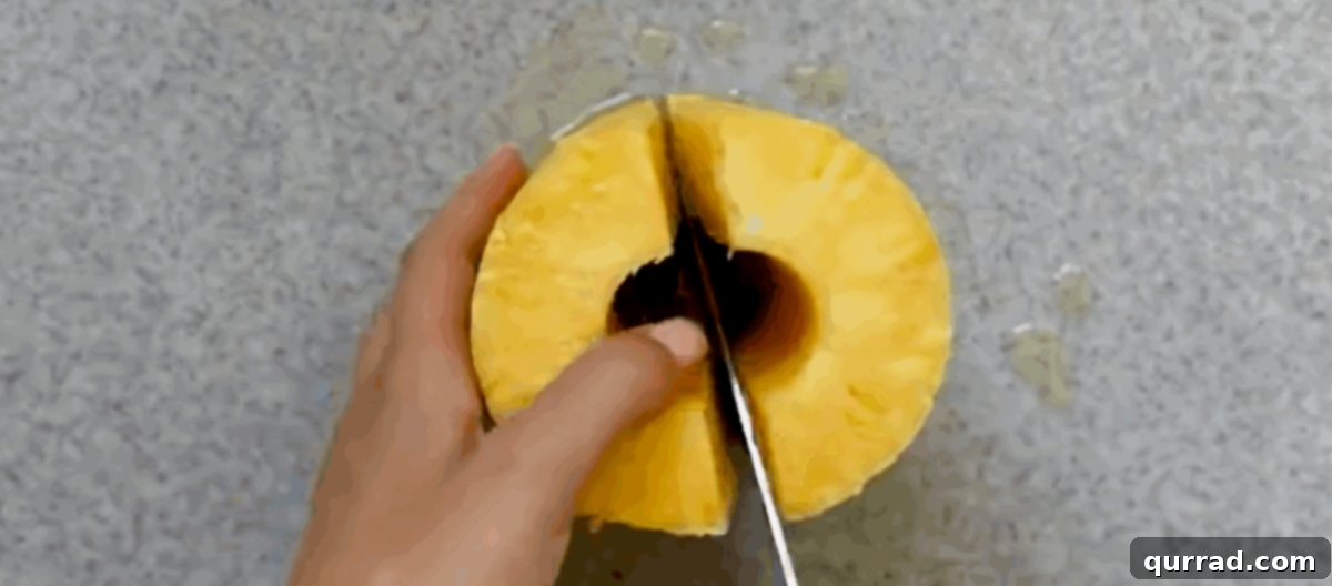 Caramelized Air Fryer Pineapple 4 Cutting a peeled pineapple.