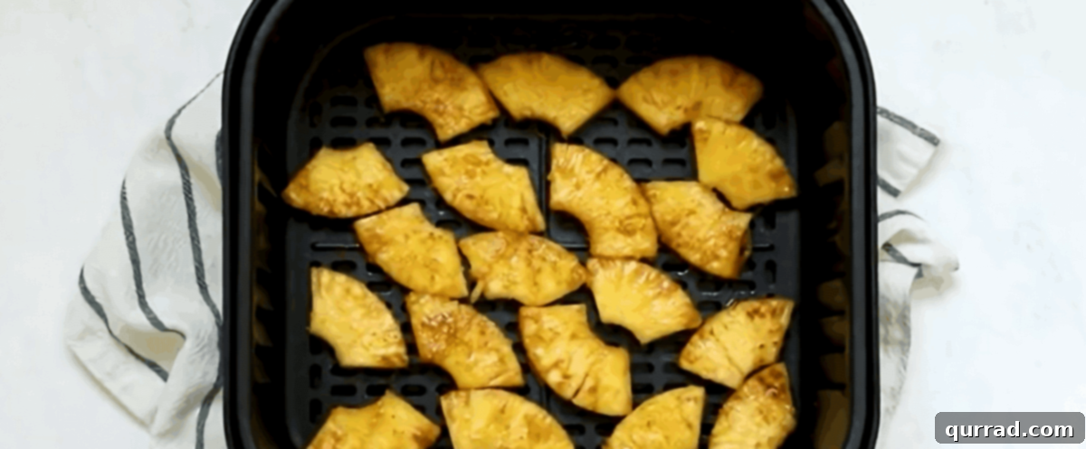 Caramelized Air Fryer Pineapple 6 Pineapple slices in an air fryer.