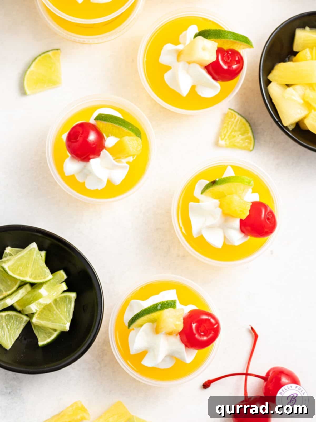 Island Escape Mai Tai Jellies 5 yellow jello shots garnished with whipped cream, lime wedge, and maraschino cherry