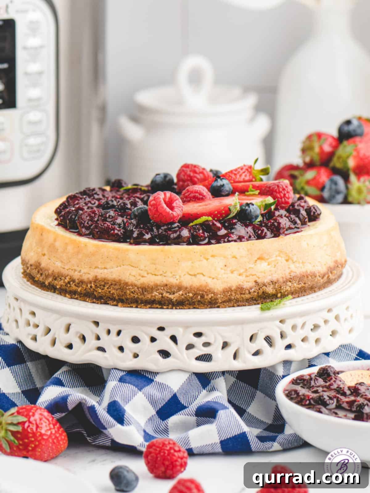 Flawless Instant Pot Cheesecake 3 An Instant Pot cheesecake with berry compote on a serving stand