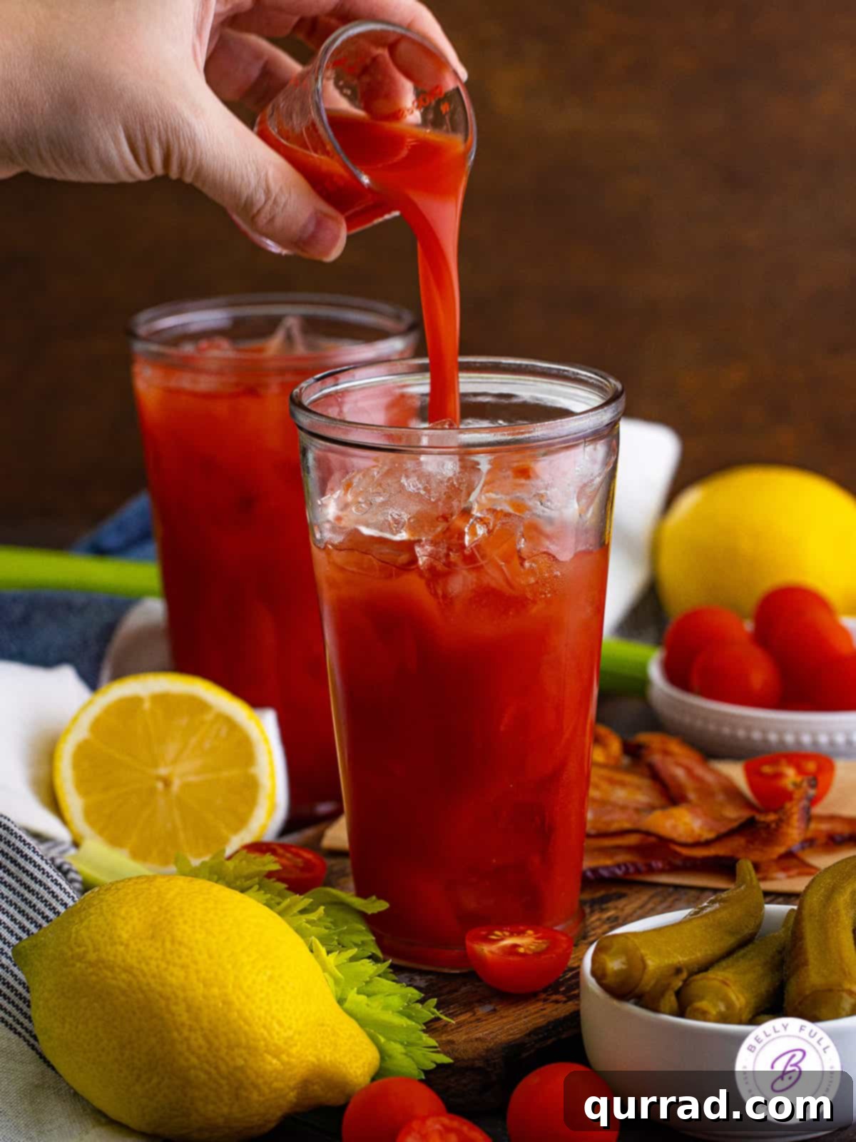 Say Her Name Thrice 4 A stream of rich, red Bloody Mary mix being poured into a tall, clear glass, signifying the start of cocktail preparation.