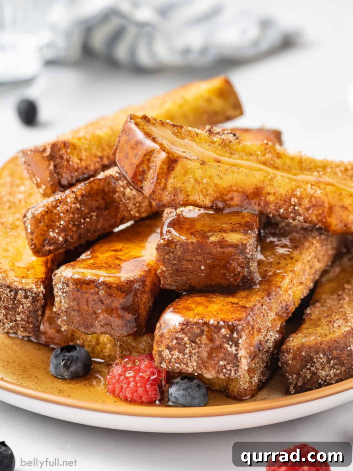 A beautifully arranged plate of golden-brown air fryer French toast sticks, ready to be served for breakfast.
