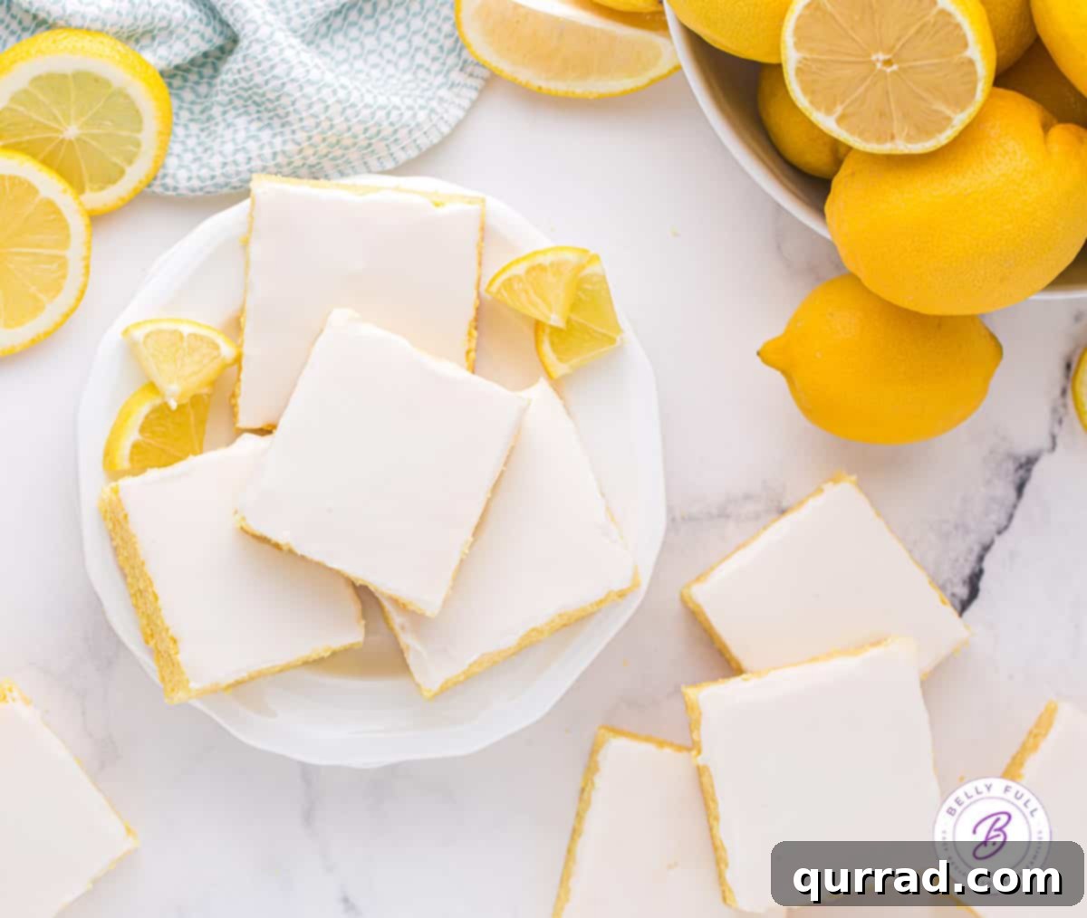 Soft and moist, these Lemon Blondies are the ultimate easy lemon dessert. Just 9 ingredients and a few steps to make! Overhead view of a plate of perfectly cut lemon blondies, showing the thick, vibrant glaze.