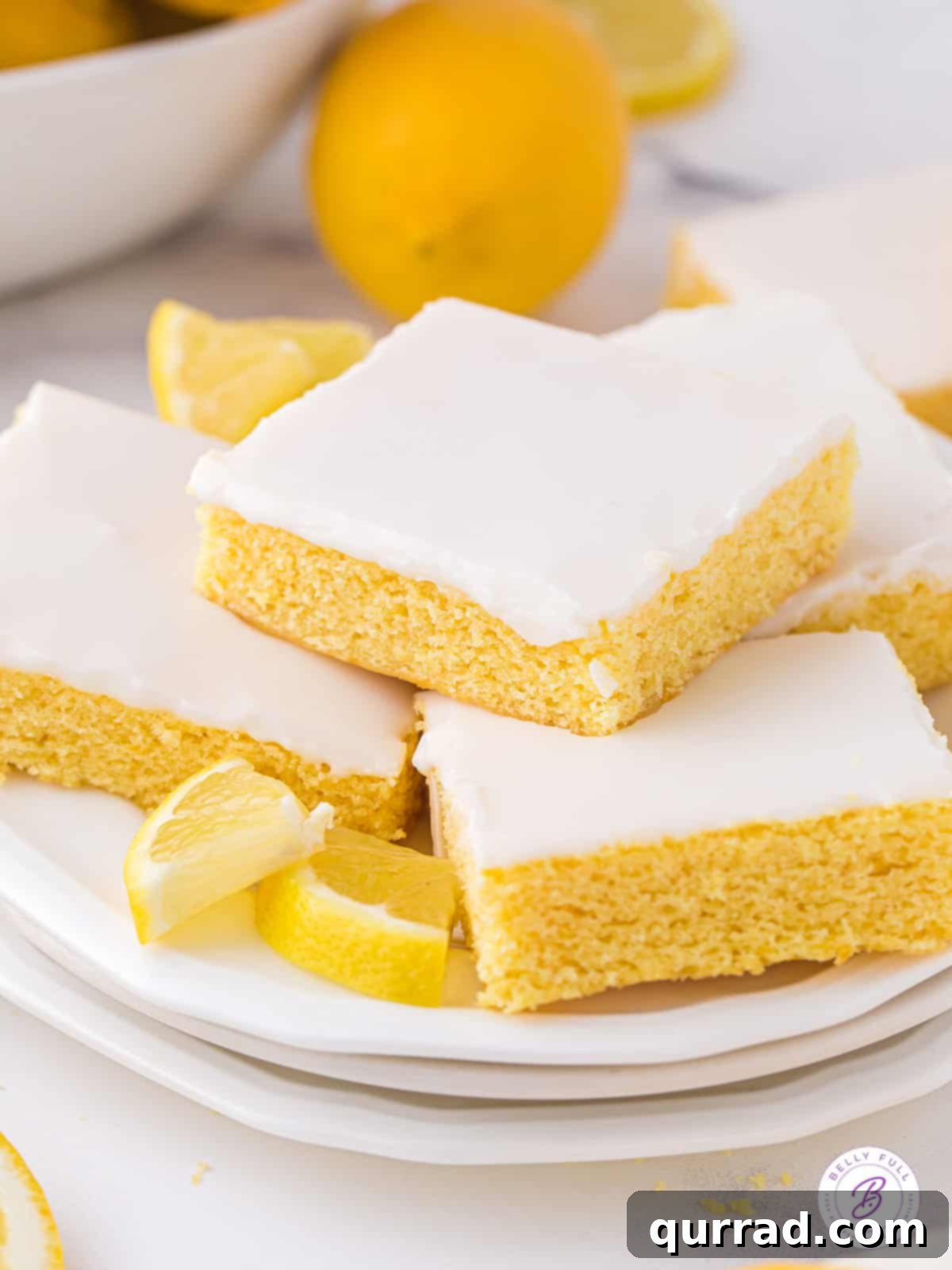 Soft and moist, these Lemon Blondies are the ultimate easy lemon dessert. Just 9 ingredients and a few steps to make! Angled overhead view of a plate of lemon blondies, ready to be enjoyed.