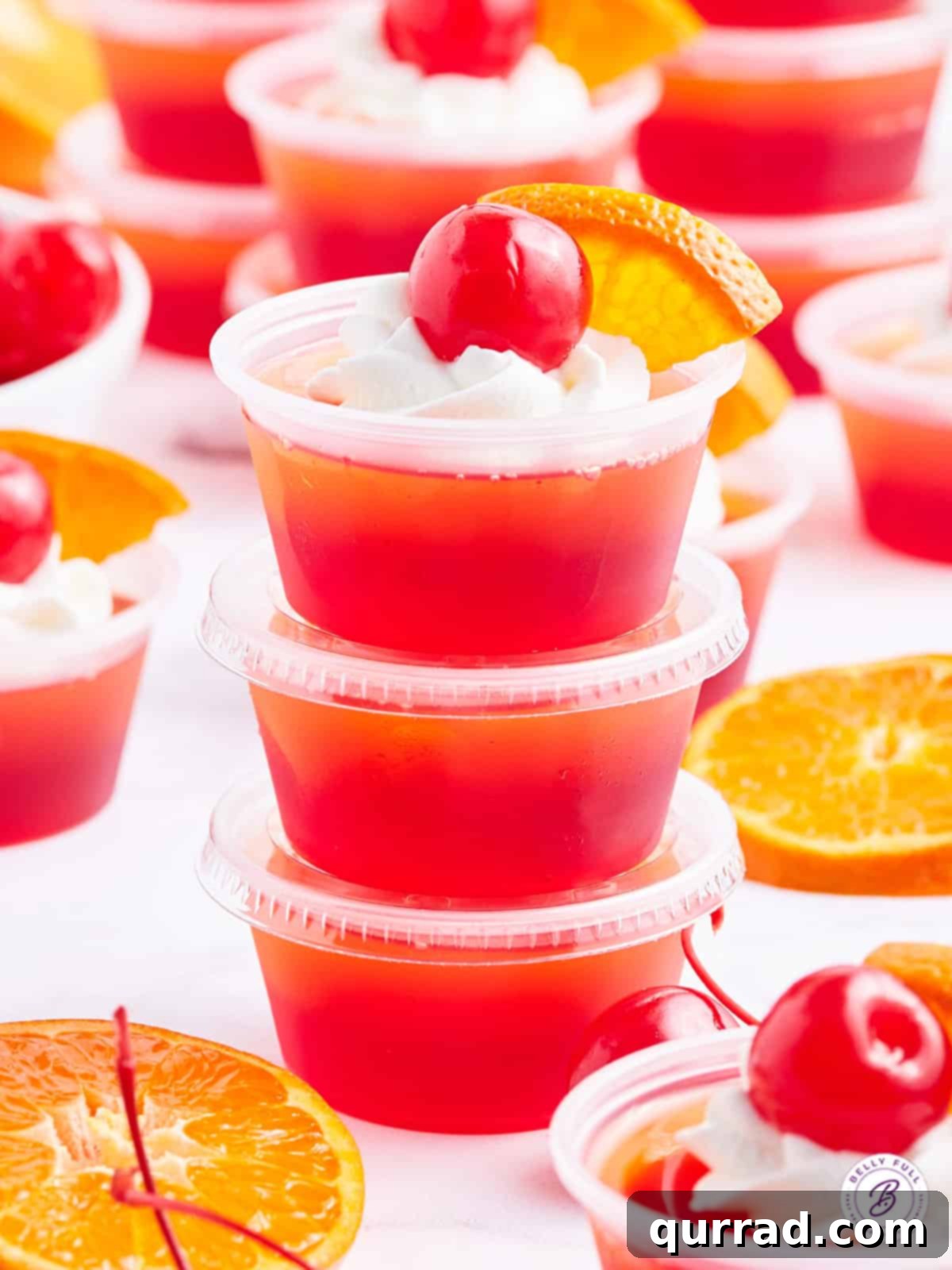 Fiesta Sunrise Jellies 2 stack of 3 tequila sunrise jello shots garnished with whipped cream and a cherry