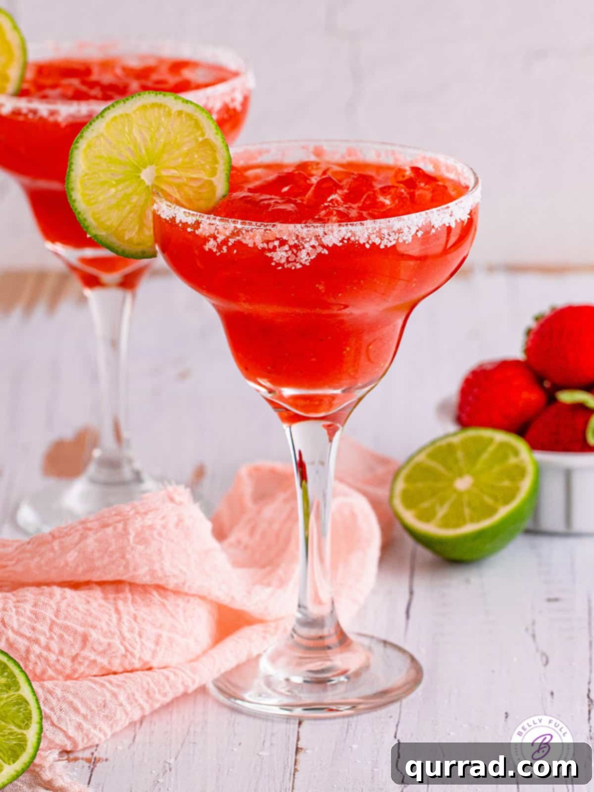 Refreshing, sweet, and tart this Strawberry Margarita is made with just 6 ingredients, with no margarita mix. Perfect for parties! A strawberry margarita garnished with a lime slice, depicting a refreshing summer drink.