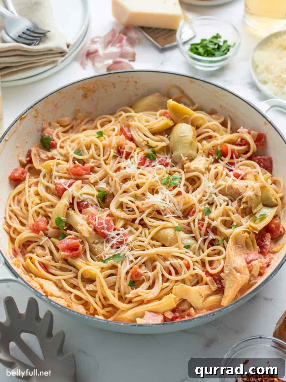 pasta with artichokes and tomatoes in white pan
