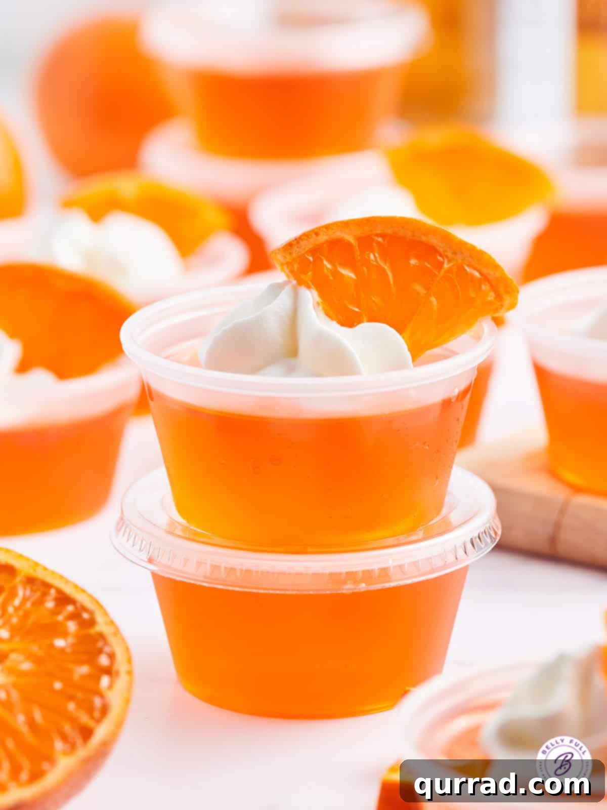 two stacked orange creamsicle jello shots with whipped cream
