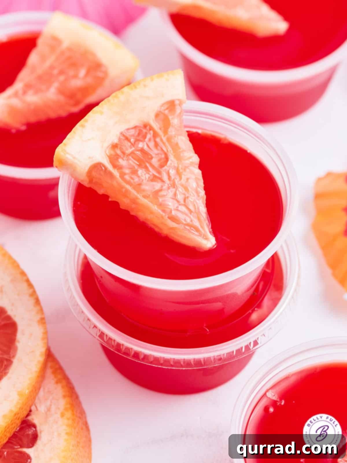 close up sea breeze jello shot garnished with a tiny grapefruit wedge