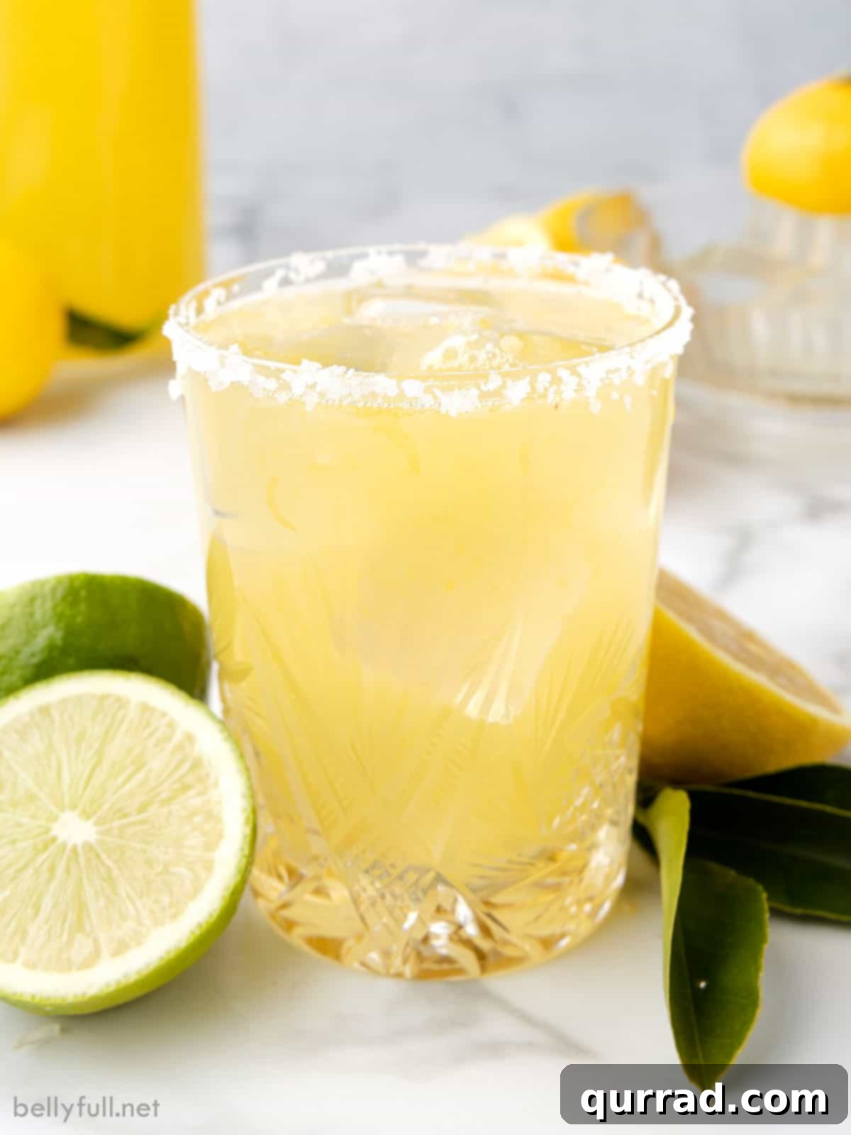 A perfectly crafted margarita, featuring a salt rim and lime wedge, made with the Easy Homemade Margarita Mix. A beautifully garnished glass of margarita on a wooden surface.