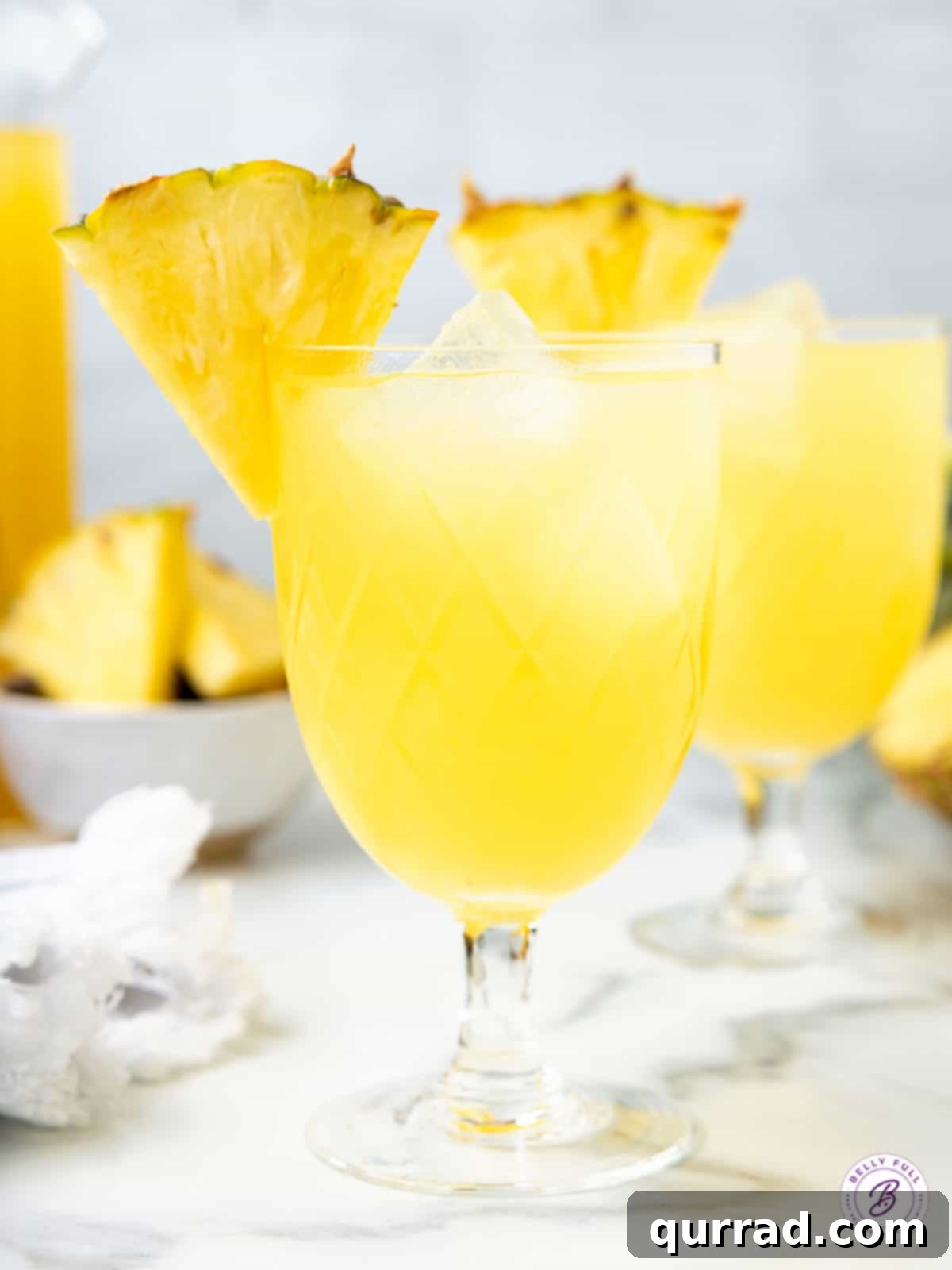 Pineapple rum punch in glass with pineapple wedge garnish