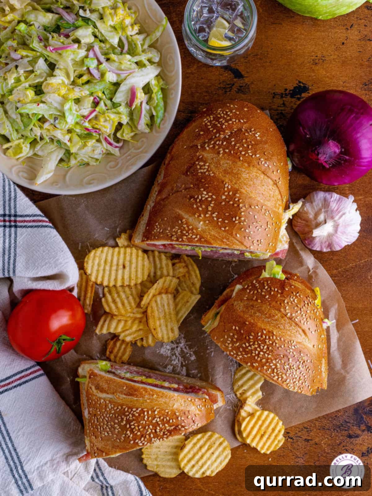 Piled high with meats, cheese, and a tangy, irresistible grinder salad, this Italian Grinder Sandwich Recipe is perfect for feeding a crowd. Overhead view of a beautifully cut Italian grinder sandwich, revealing all its delicious layers.