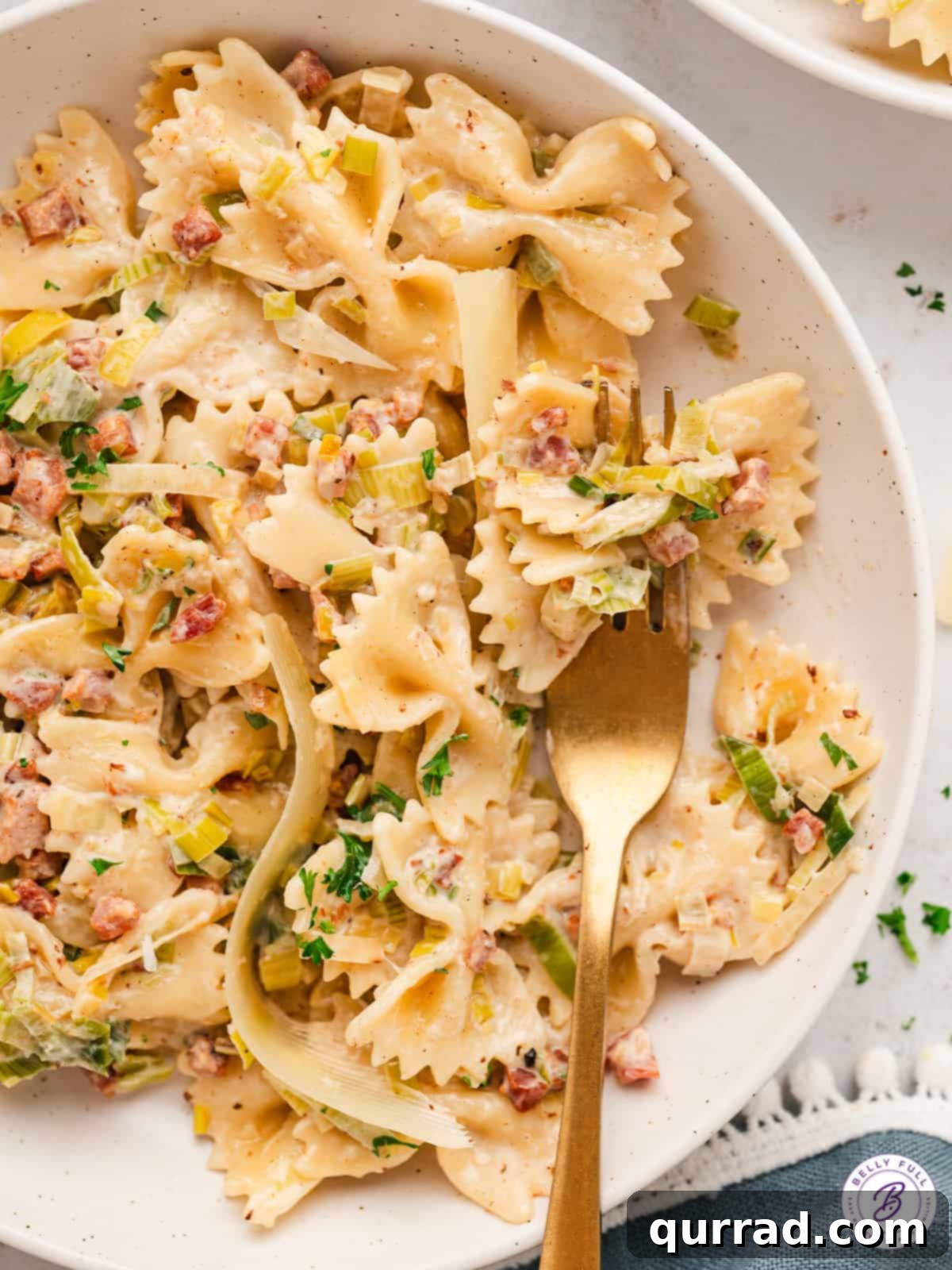 Creamy Farfalle with Pancetta and Leeks in bowl with fork