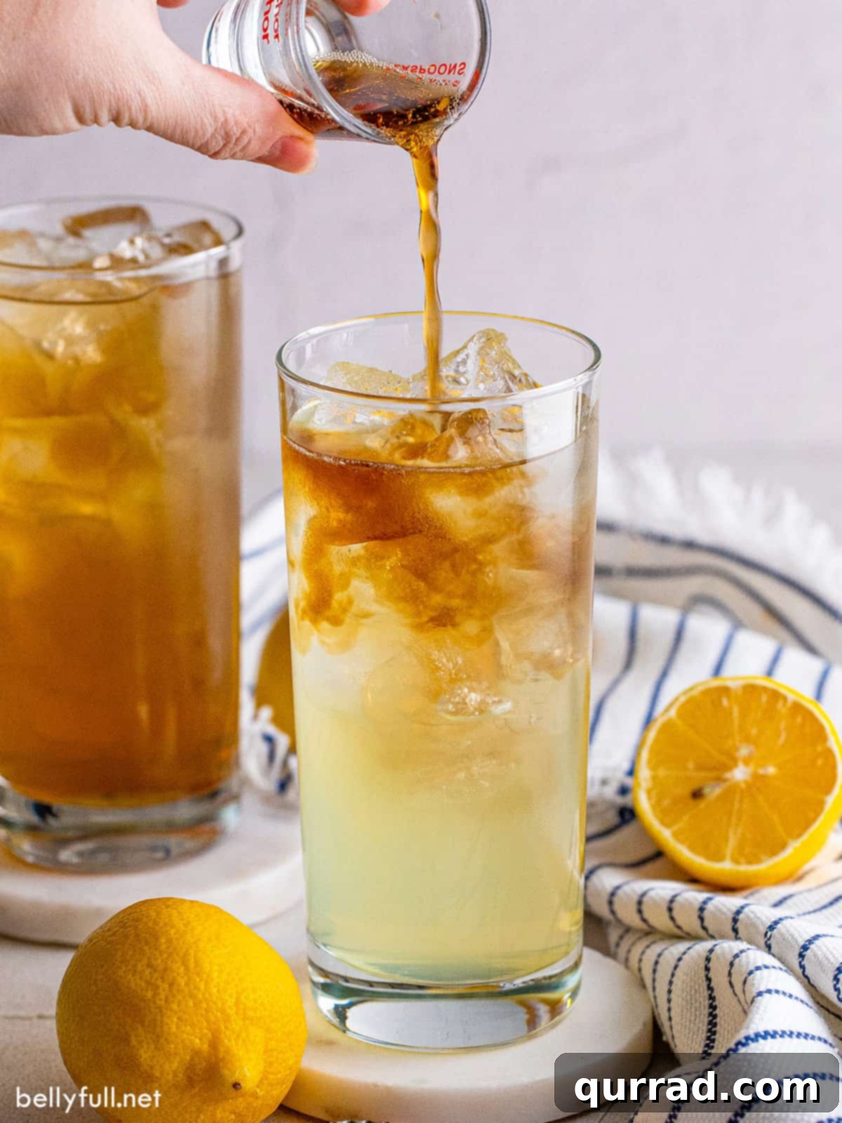 Finishing a Long Island Iced Tea with Coca-Cola Coca-Cola being poured into a Long Island Iced Tea, illustrating the final step of preparation