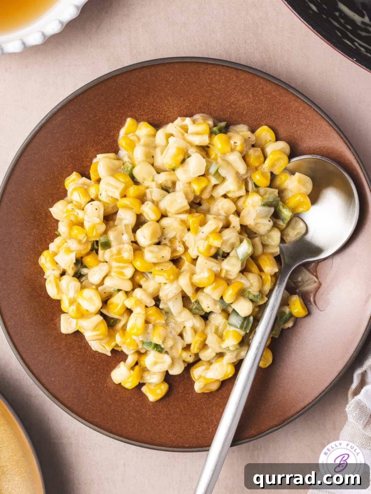 Honey Butter Kissed Skillet Corn 3 overhead creamy corn in bowl with spoon