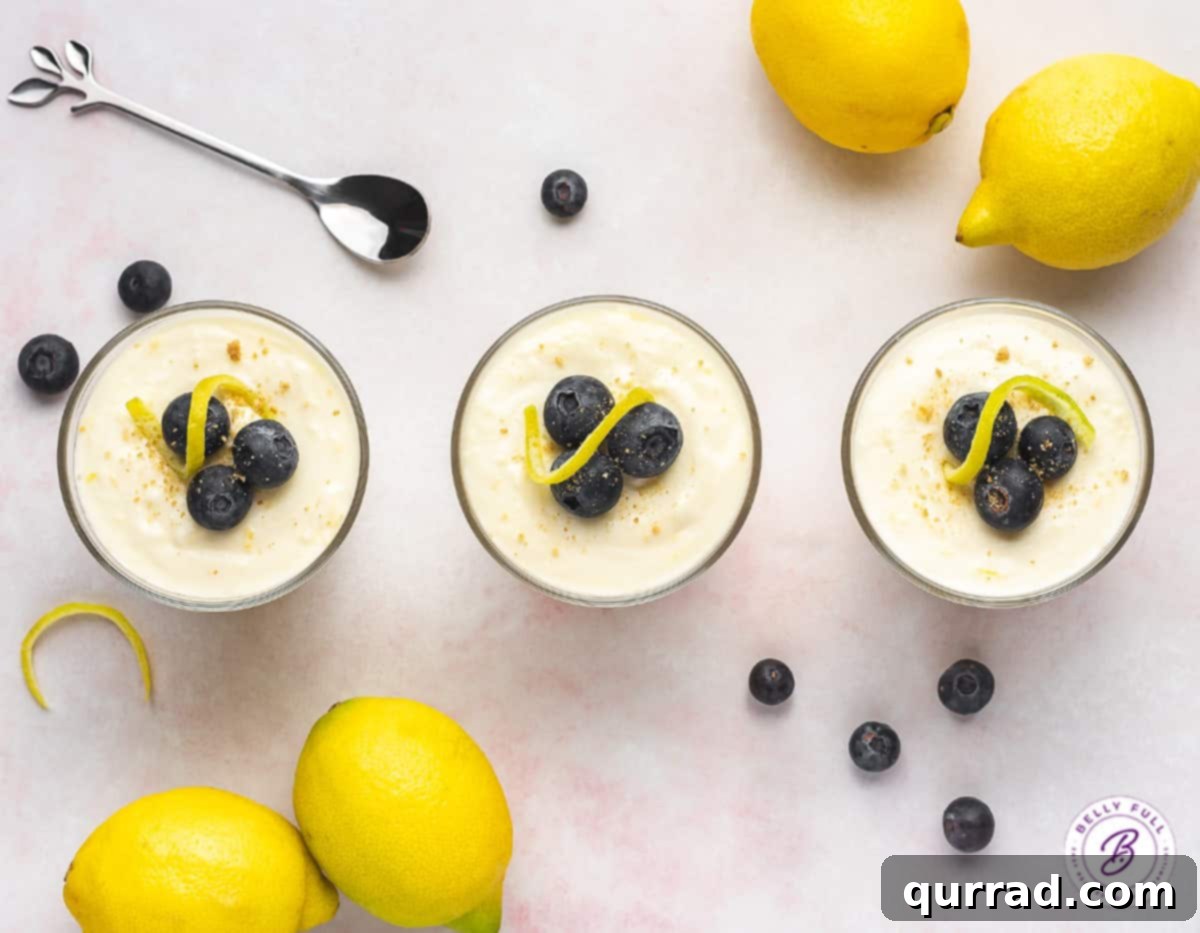 Enjoy the light and creamy texture of this Lemon Cheesecake Mousse, an ideal no-bake dessert for spring and summer gatherings! Overhead view of three individual lemon cheesecake mousse servings, beautifully presented in glass cups with fresh garnishes.
