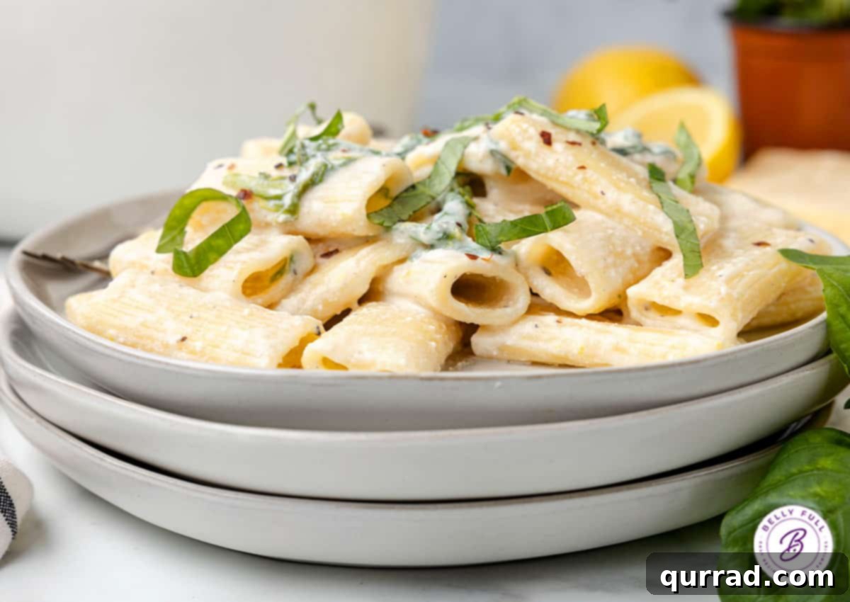 creamy rigatoni pasta with fresh julienned basil on plate