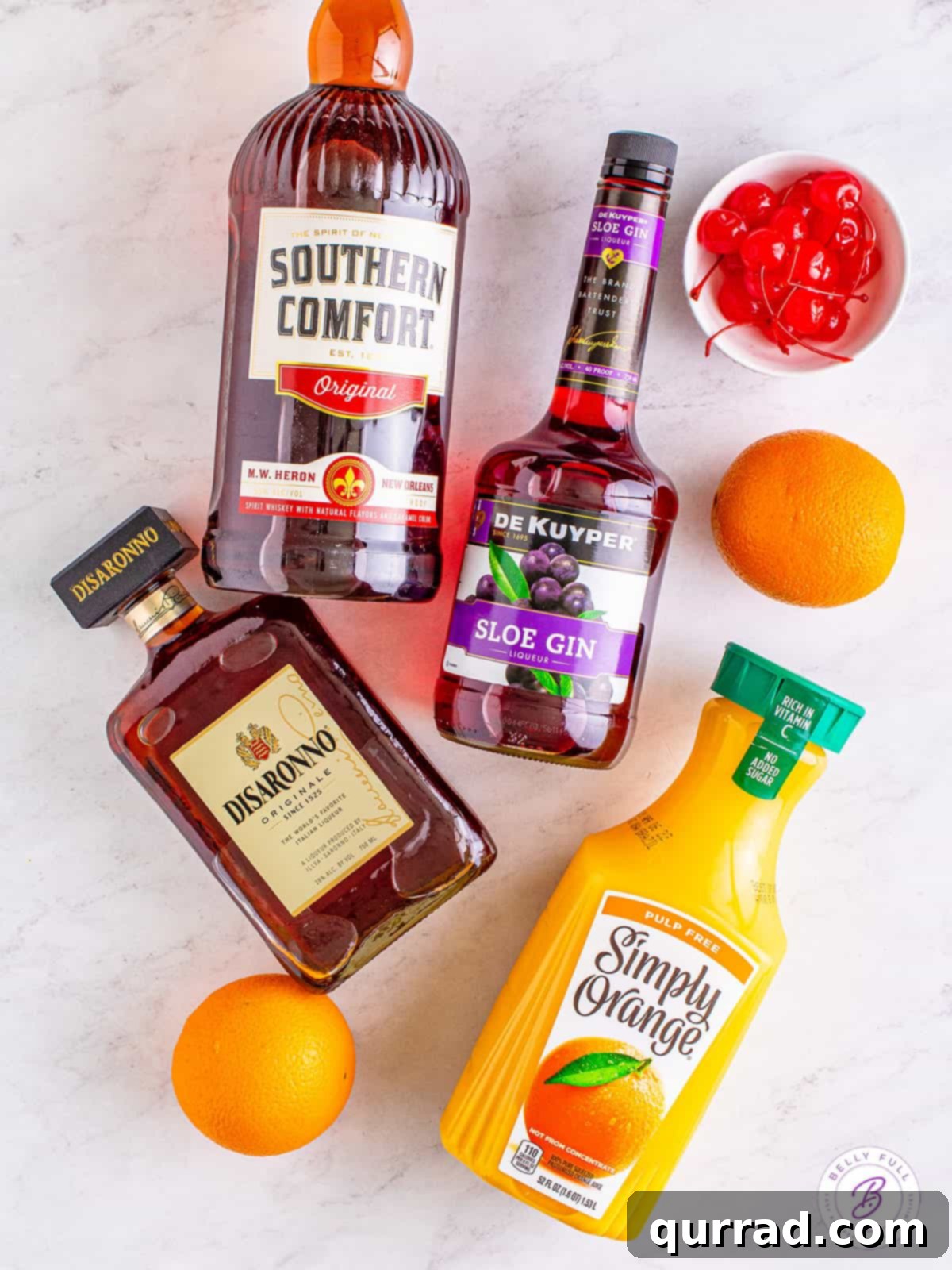 Made with 3 liqueurs and orange juice, an Alabama Slammer is a fruity and sweet cocktail that packs a punch! It's perfect for sipping! Overhead view of Alabama Slammer cocktail ingredients