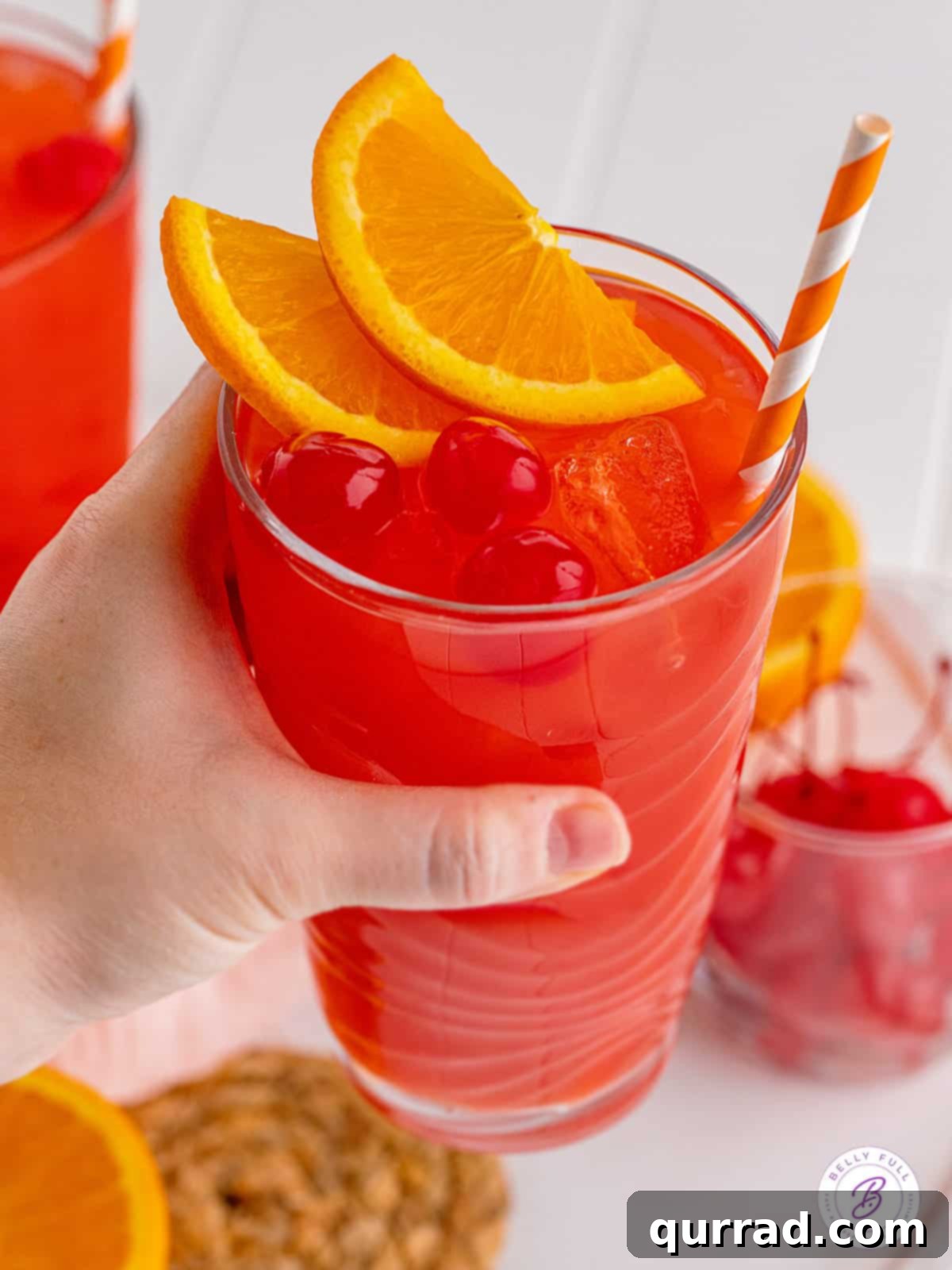 Made with 3 liqueurs and orange juice, an Alabama Slammer is a fruity and sweet cocktail that packs a punch! It's perfect for sipping! A hand holding an Alabama Slammer cocktail