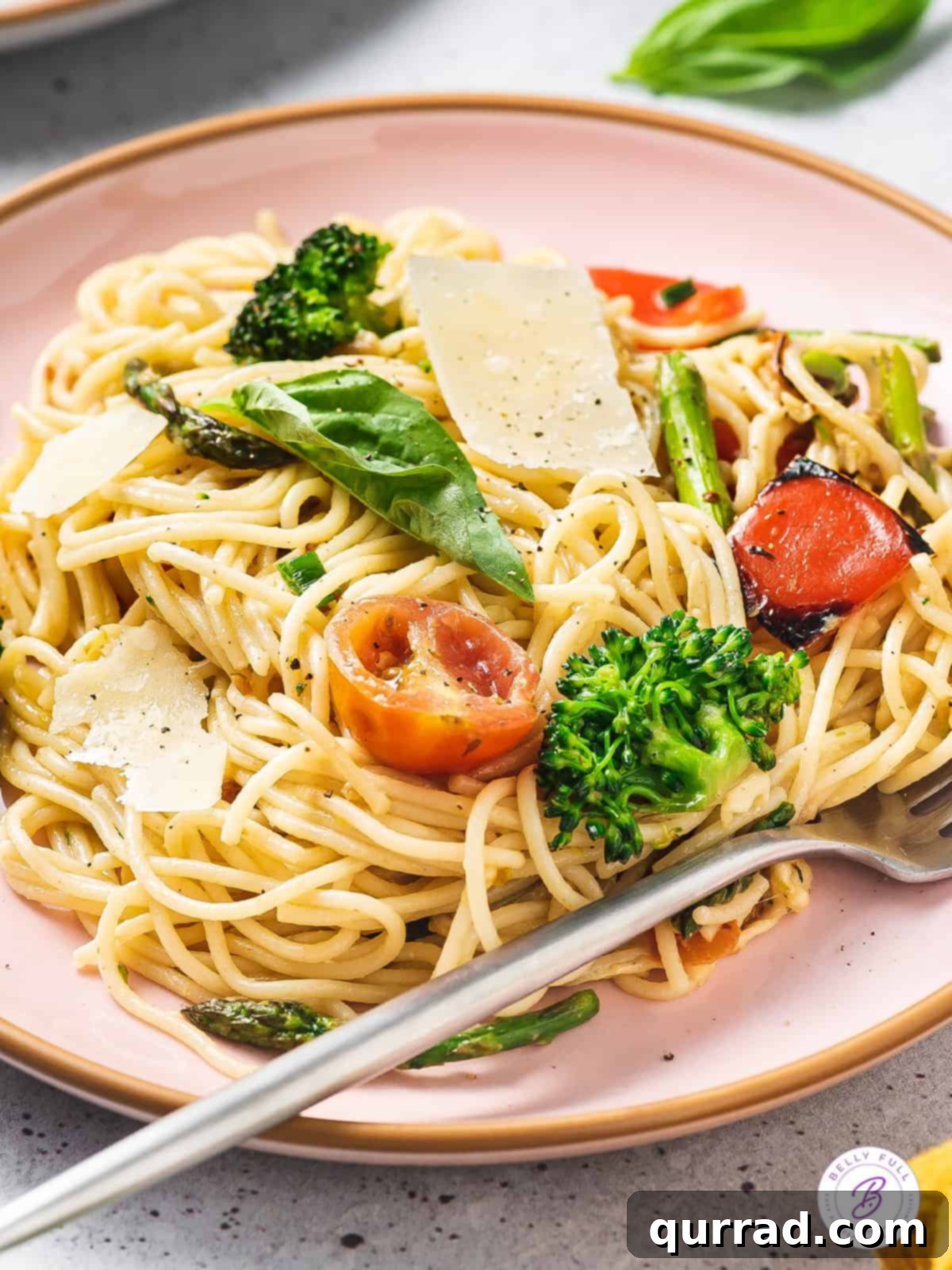 Loaded with fresh veggies like broccoli and asparagus and a lemon cream sauce, Pasta Primavera is a quick and easy dinner recipe. Angled view of a single serving plate of pasta primavera, garnished with fresh basil and Parmesan cheese.