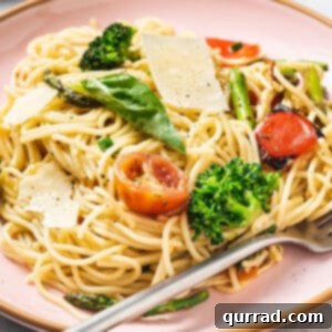 Vibrant Veggie Pasta 2 Angled view of a plate of pasta primavera with tomatoes, parmesan, and broccoli.