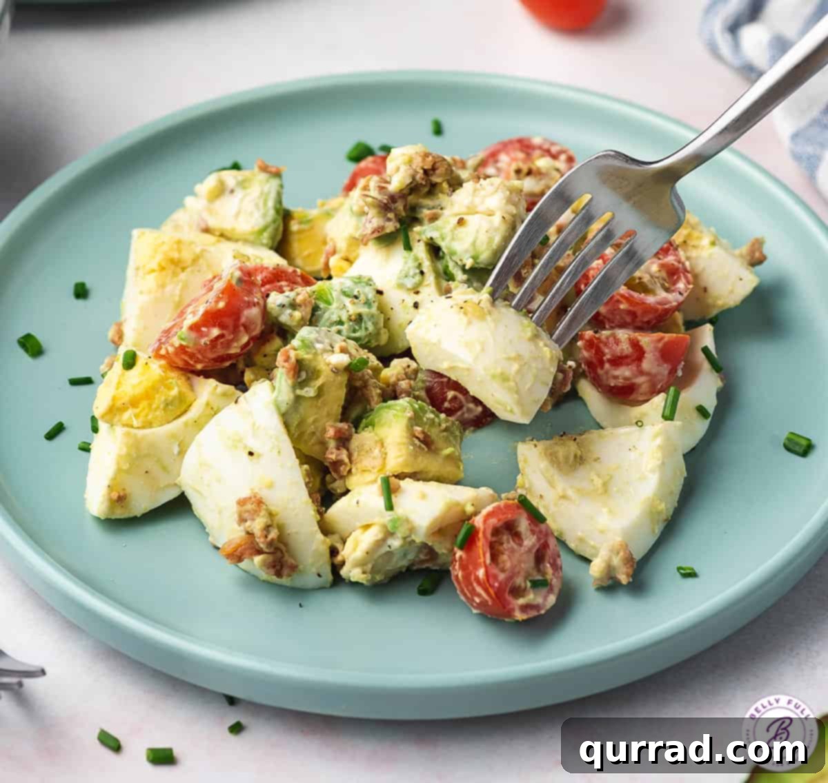 Ultimate Cobb Egg Salad 5 fork full of creamy chopped hard boiled egg over salad on plate