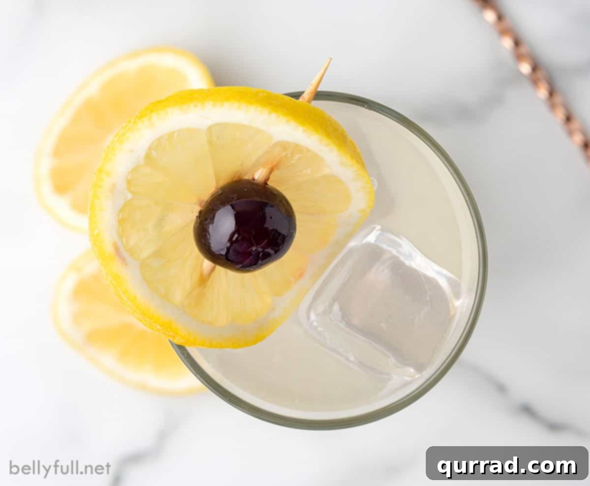 Refreshing Tom Collins Cocktail: A Top-Down View An inviting overhead view of a Tom Collins cocktail, perfectly garnished with a lemon wheel and a cherry, served in a tall glass filled with ice.